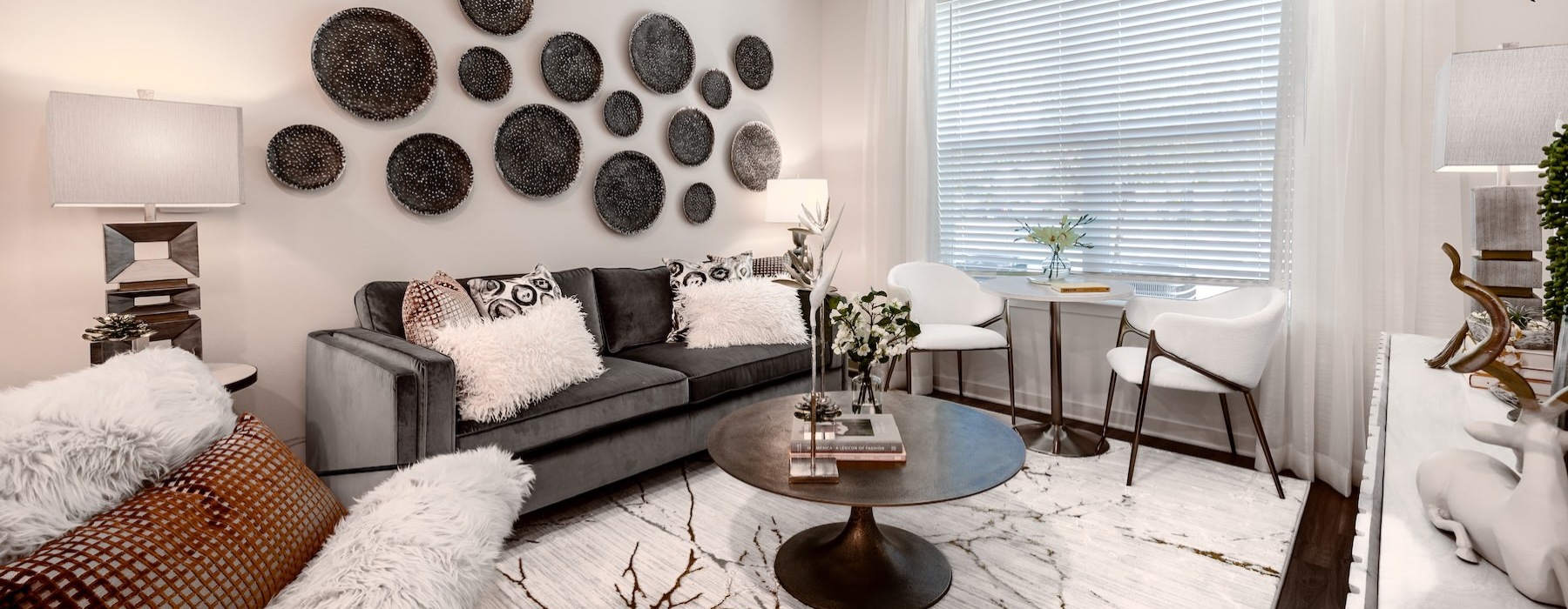 a living room with a couch, chairs and a table